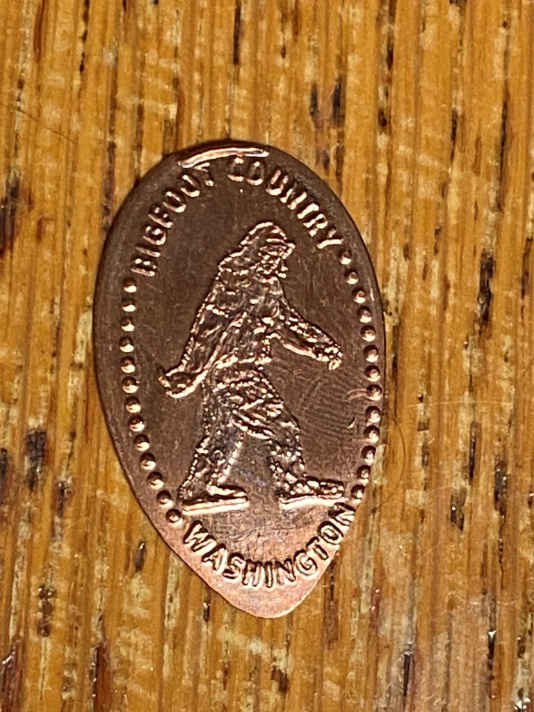 A crushed penny with an image of Bigfoot that says "Bigfoot country Washington."