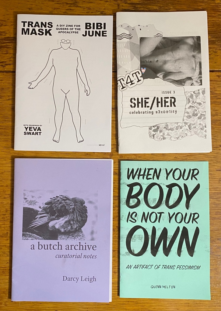Four zines on a wooden table.
